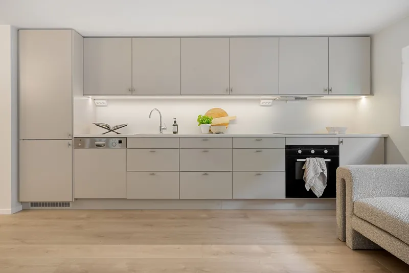 A clean, bright kitchen with pale cabinets and a wood floor